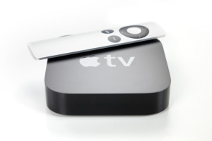 View of a second generation Apple TV and remote control, white background